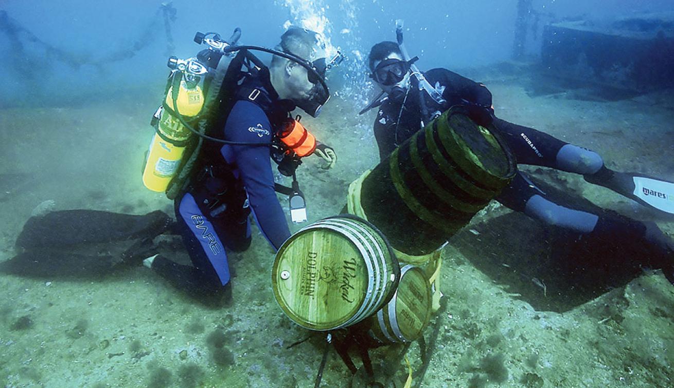 Divers Underwater with Rum Barrels
