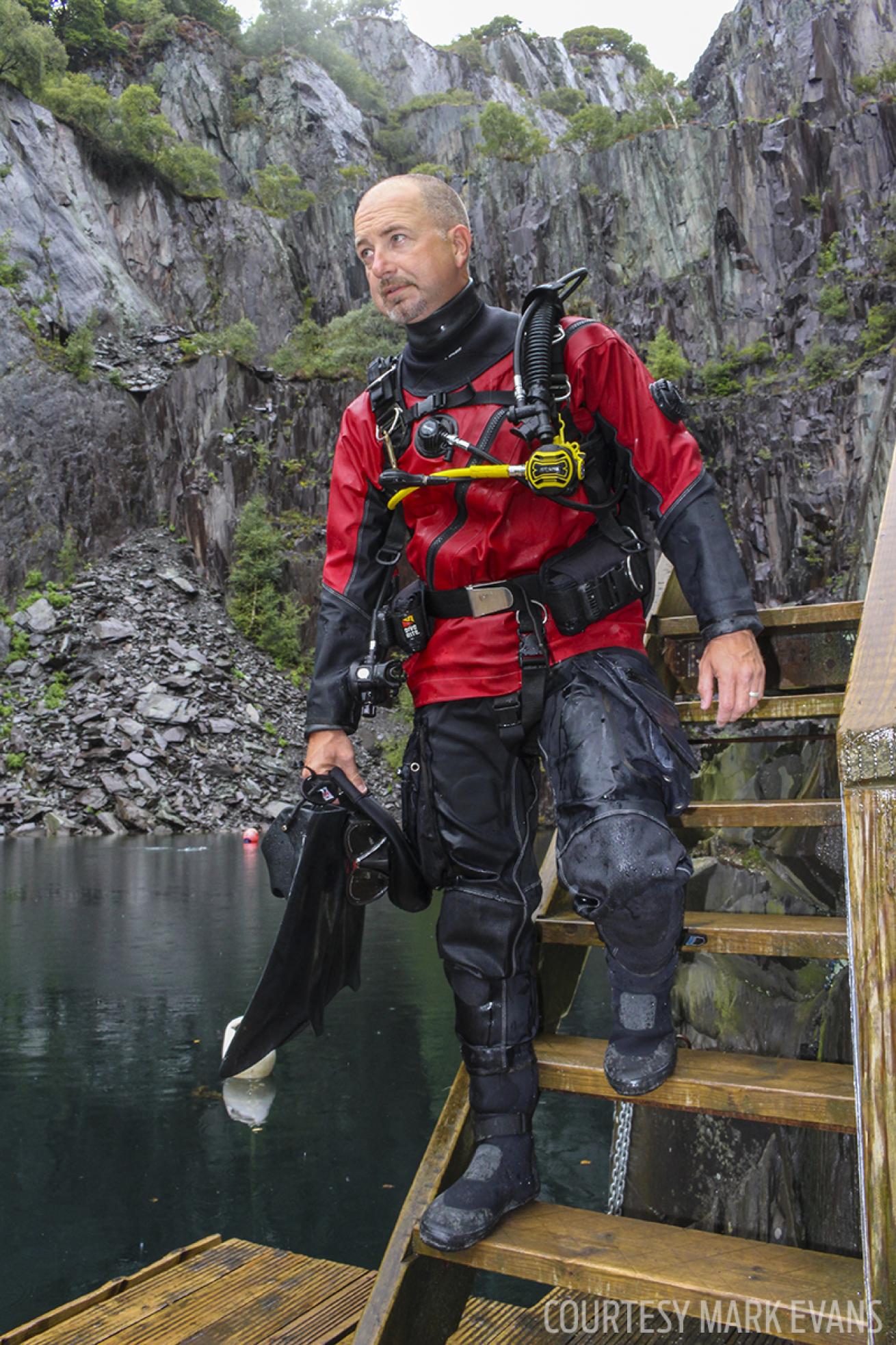 ScubaLab test diver heads toward the water in a BARE drysuit