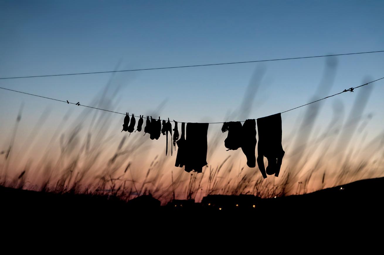 Scuba equipment dries on an outdoor clothesline.