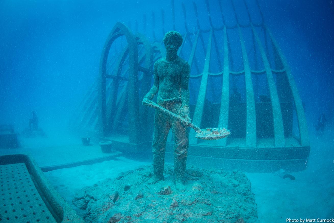 Underwater sculpture of man digging