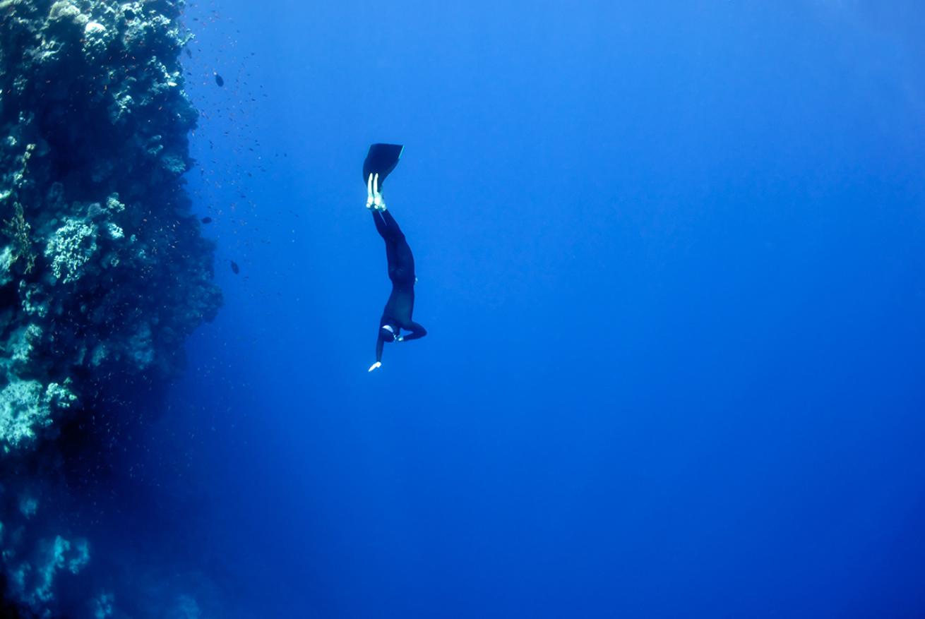 Freediver descending near wall