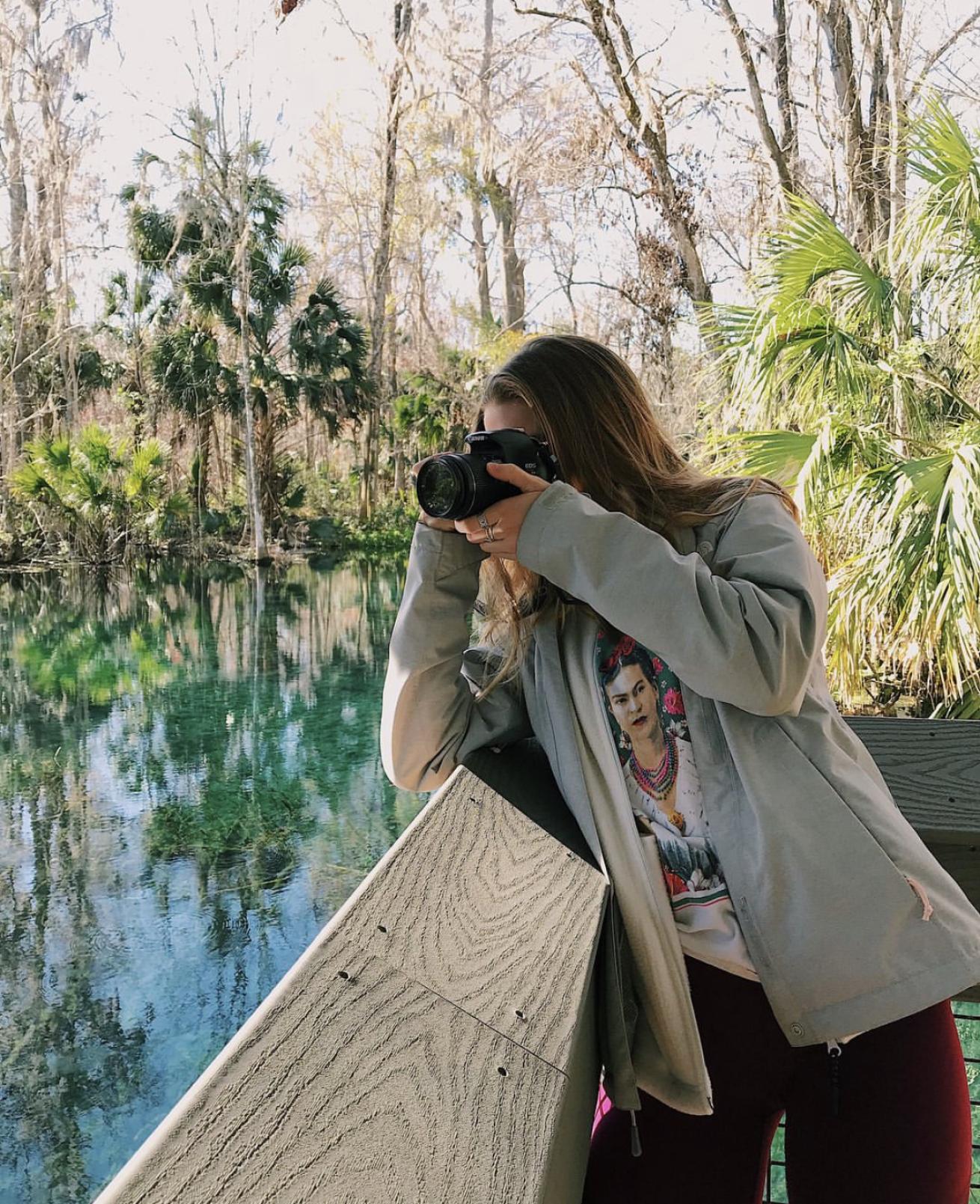A woman takes a photo of a freshwater spring in Florida