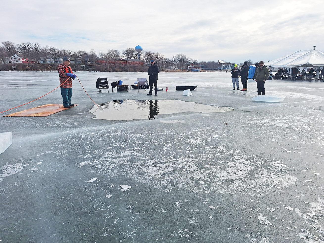 A crew stands watch at one of three ice holes.