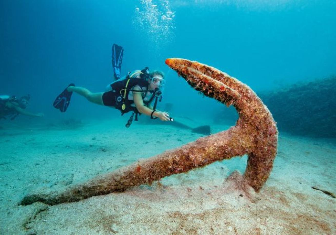 A scuba diver looking at an anchor