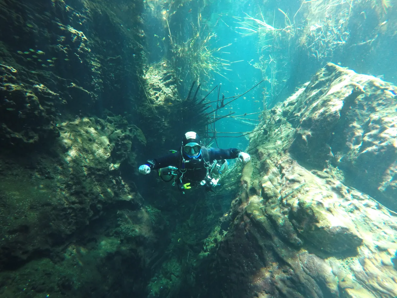 A diver emerges from a cavern dive, appearing reflective, symbolizing the shift in awareness and skill gained from the experience.