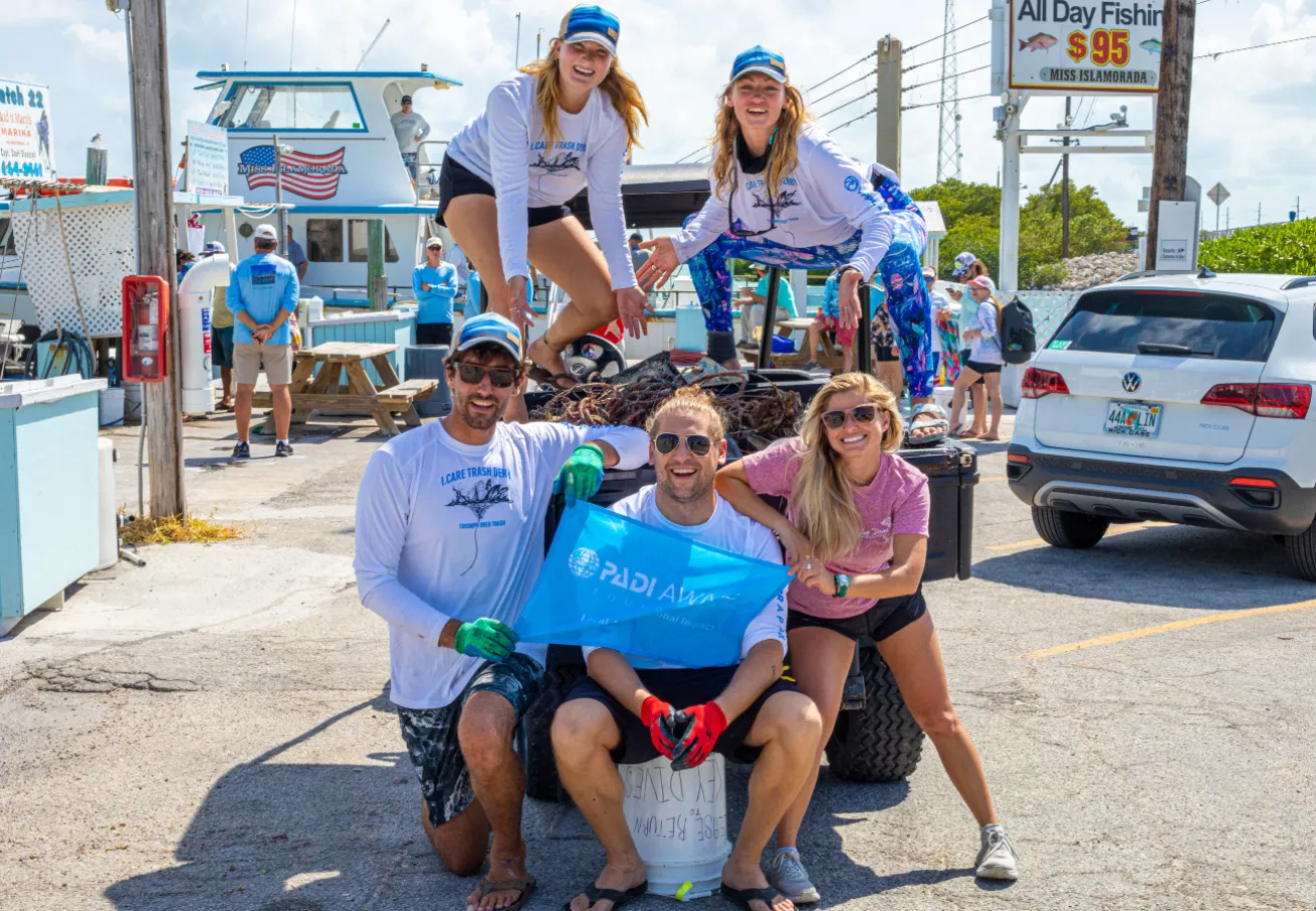A group of Derby participants posing for a picture with collected trash.