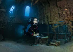 Scuba diver exploring the wreck of the Doc Poulson in Grand Cayman