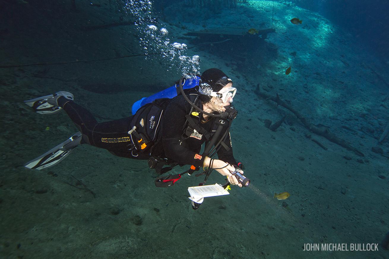 Scuba Diver Testing Dive Light Underwater in Florida Spring