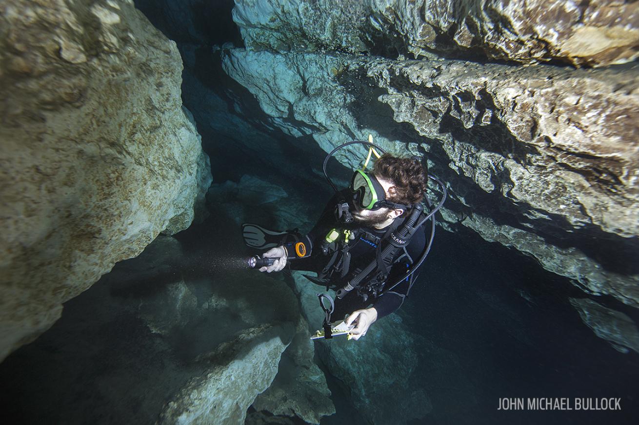 Scuba Diver Between Rocks with Dive Light in Florida Cave