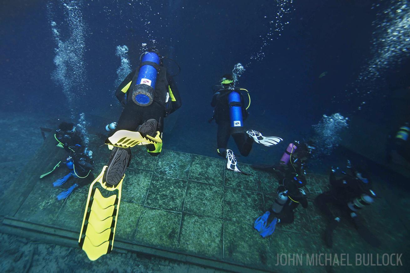 Scuba divers underwater for ScubaLab BC gear test at Blue Grotto