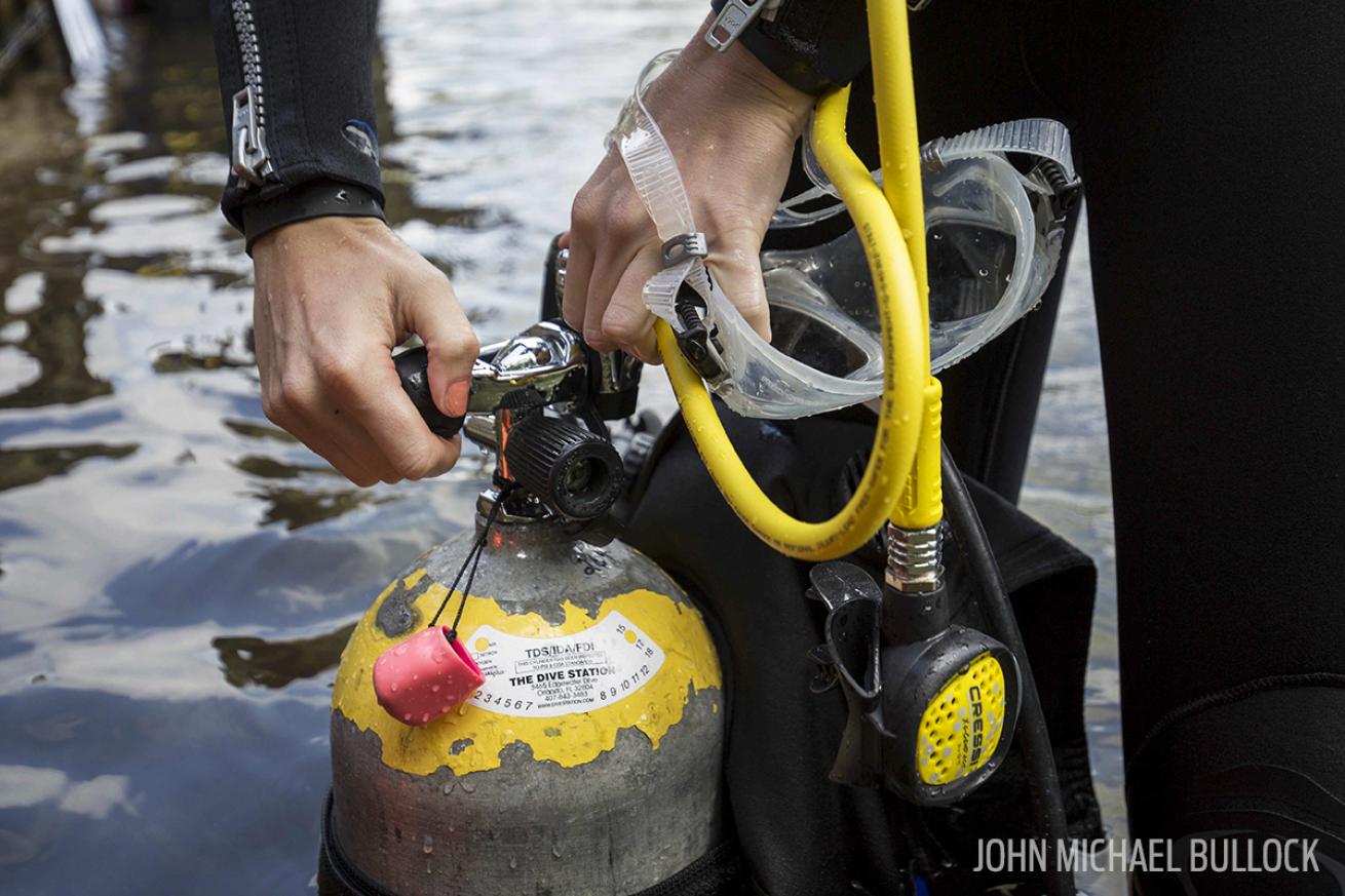 Scuba diver prepares regulator and gear