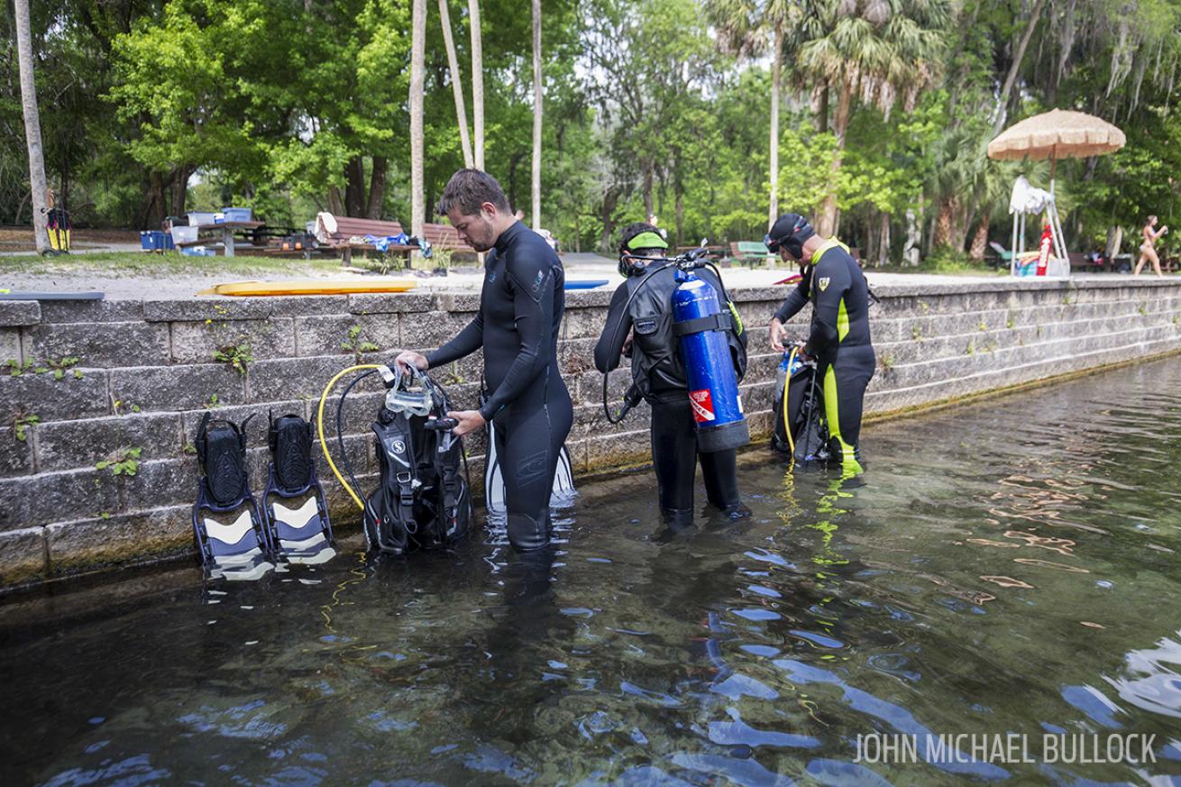 Scuba divers assemble dive gear