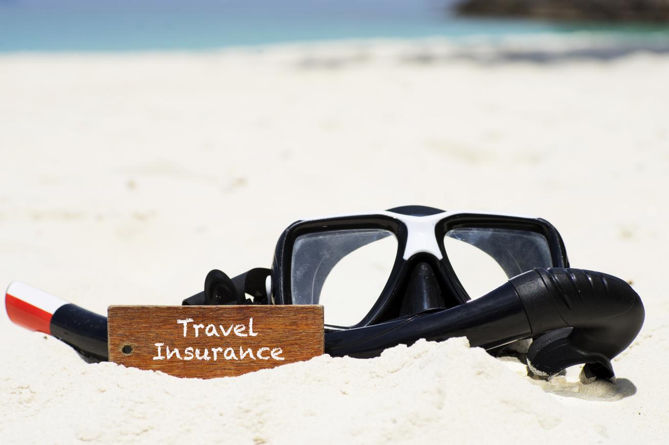 snorkel mask on beach travel insurance