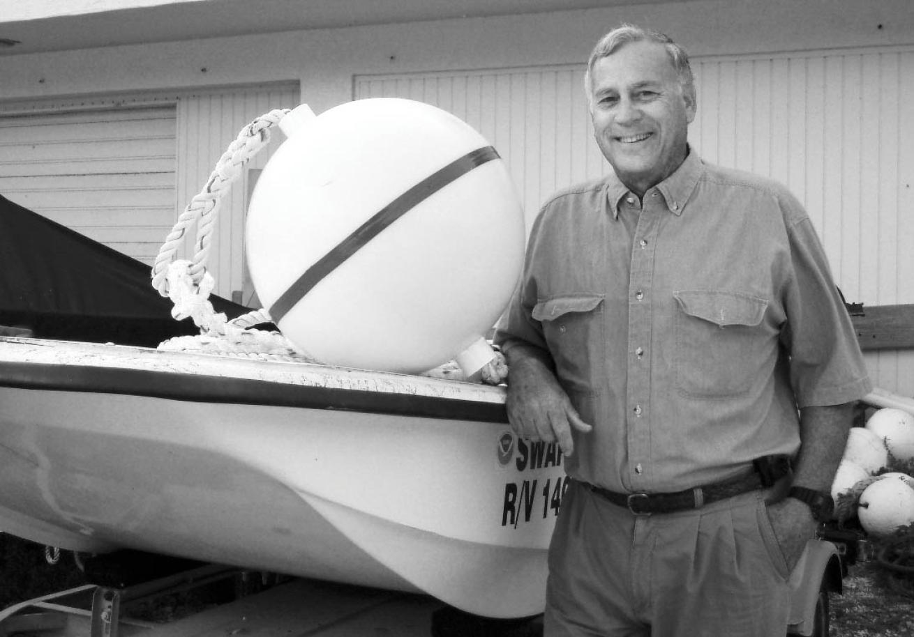 John Halas stands next to a buoy