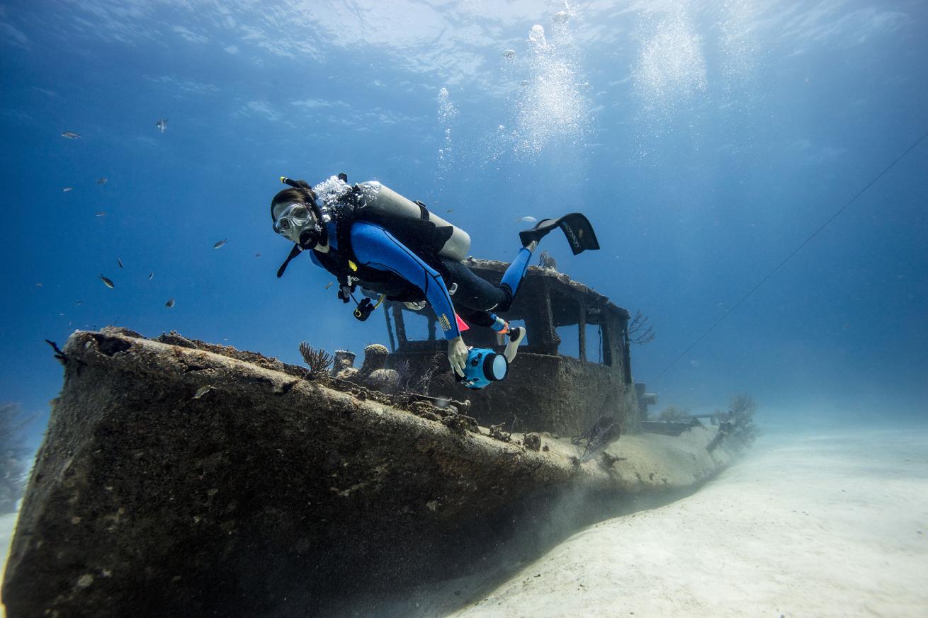 Diver with missing foot swims over a shipwreck
