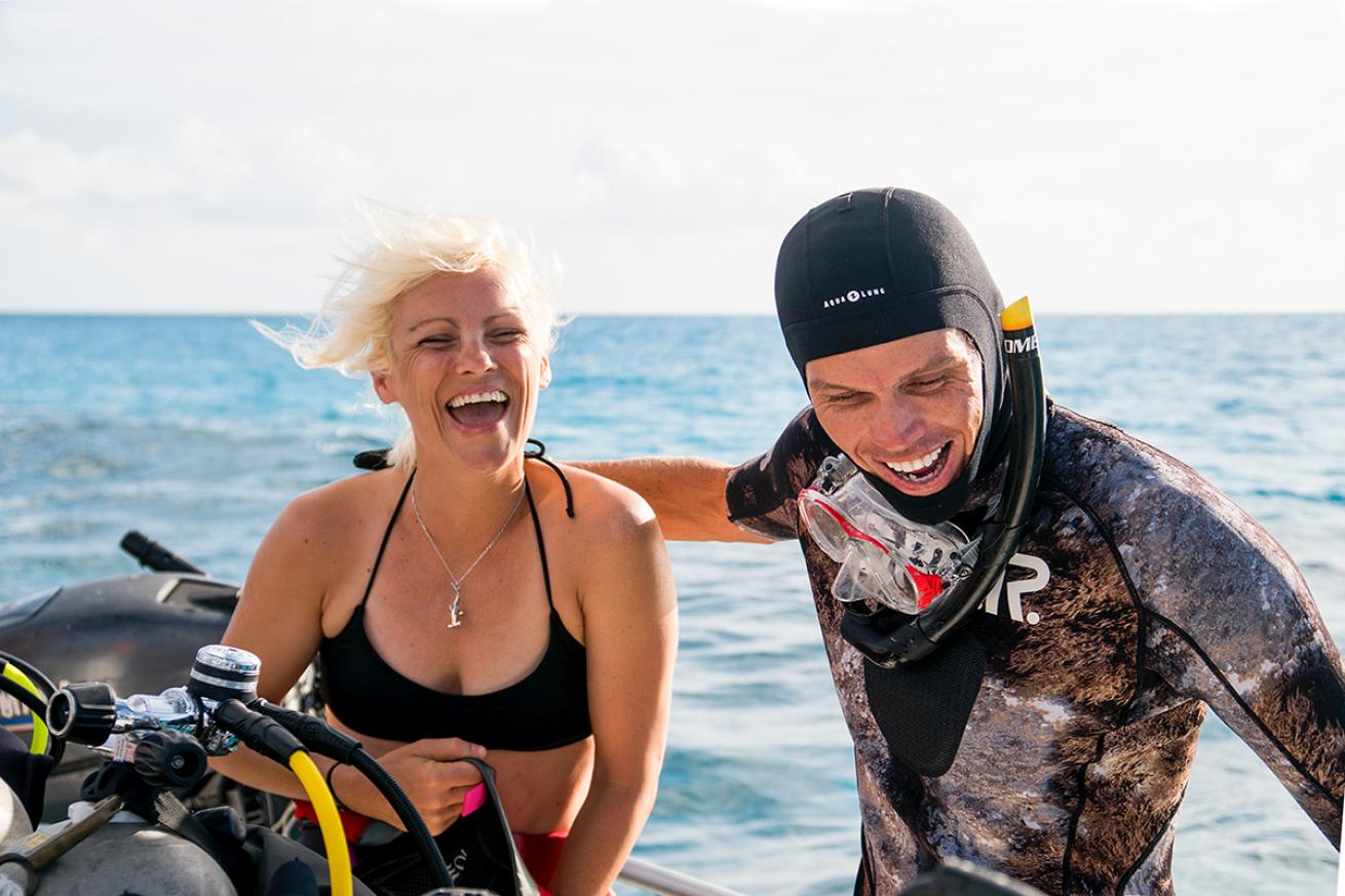 Divers laugh on a boat