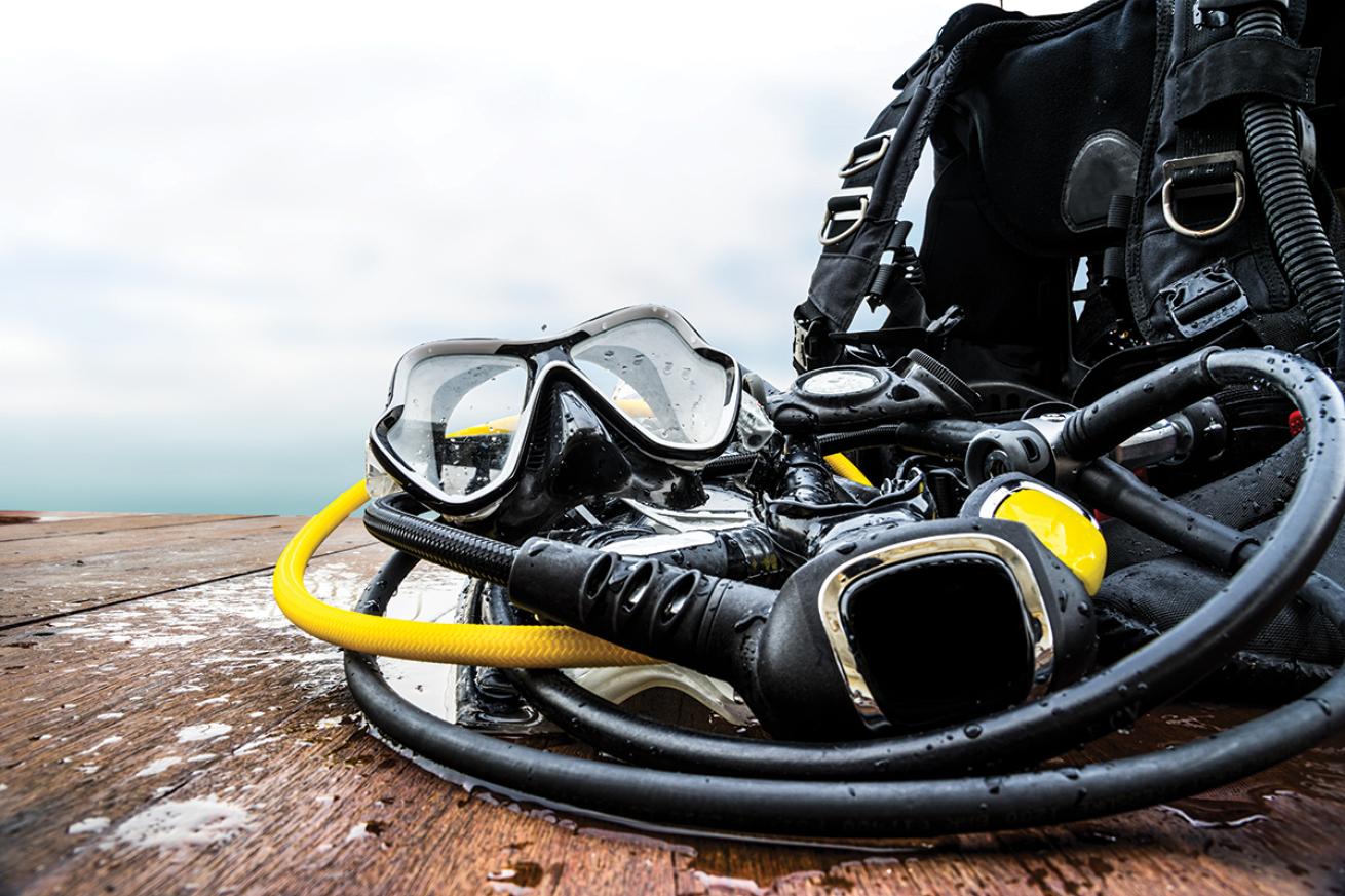 Wet scuba gear sits on a dock