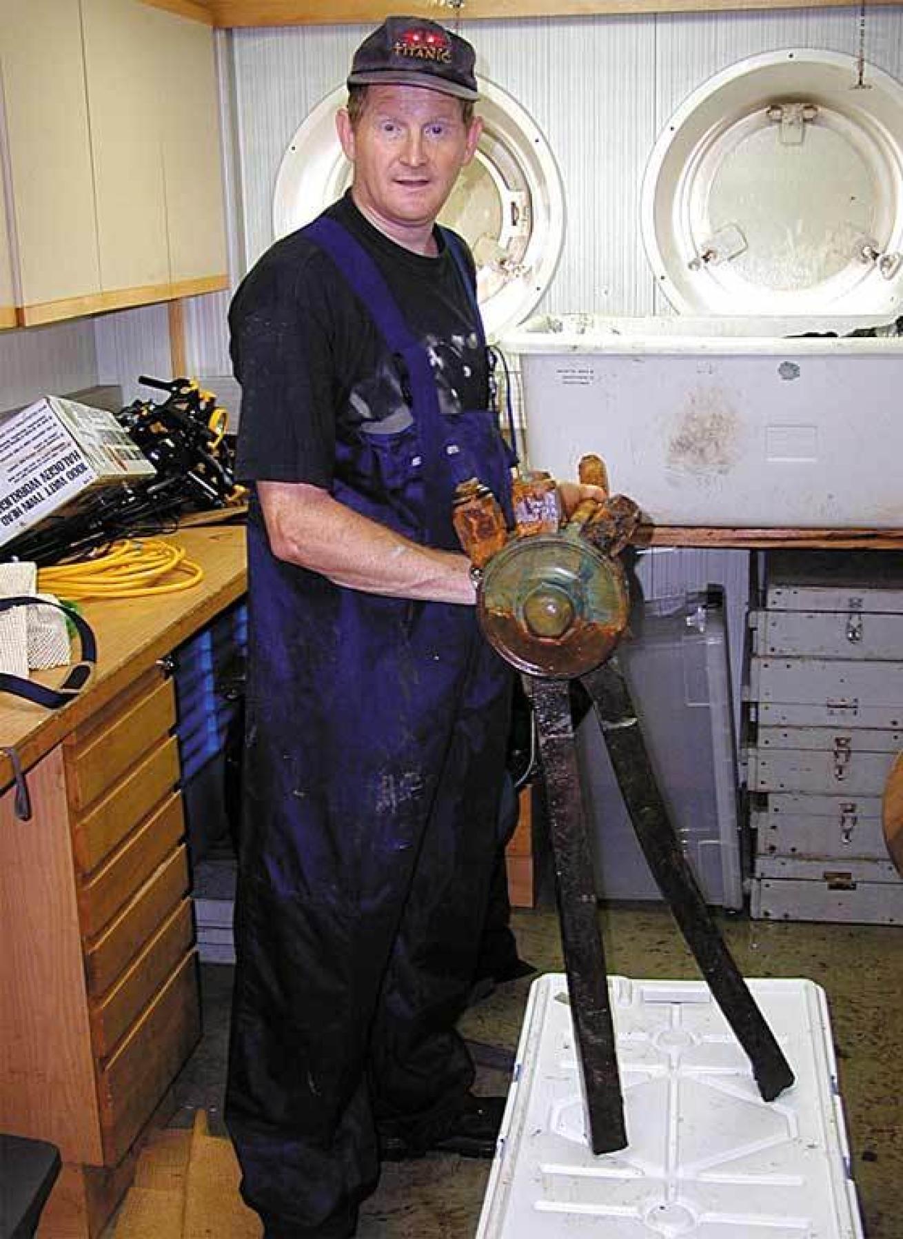 Rory Golden stands holding the wheel of the Titanic aboard the research vessel.