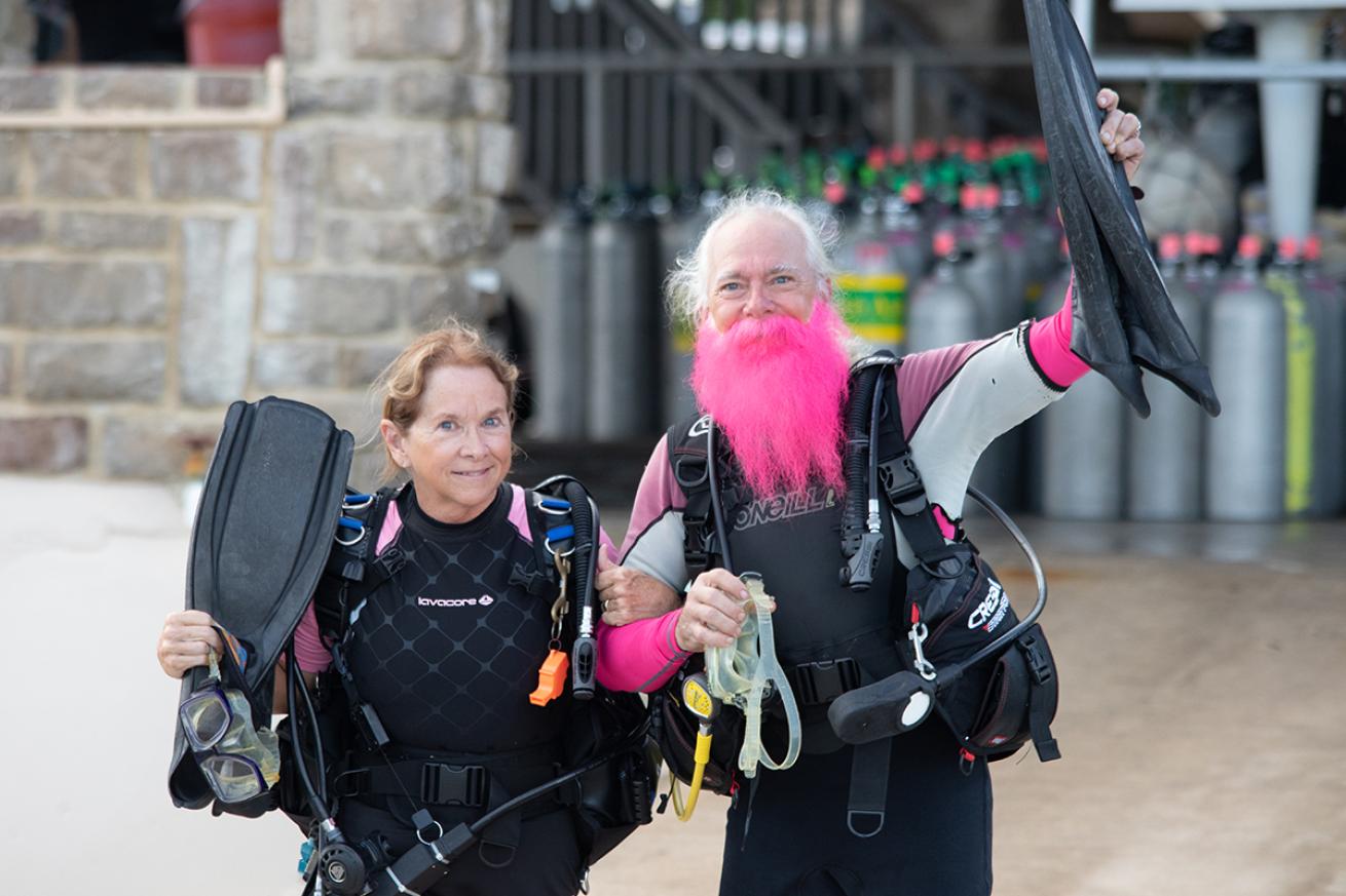 Two divers one with bright pink beard