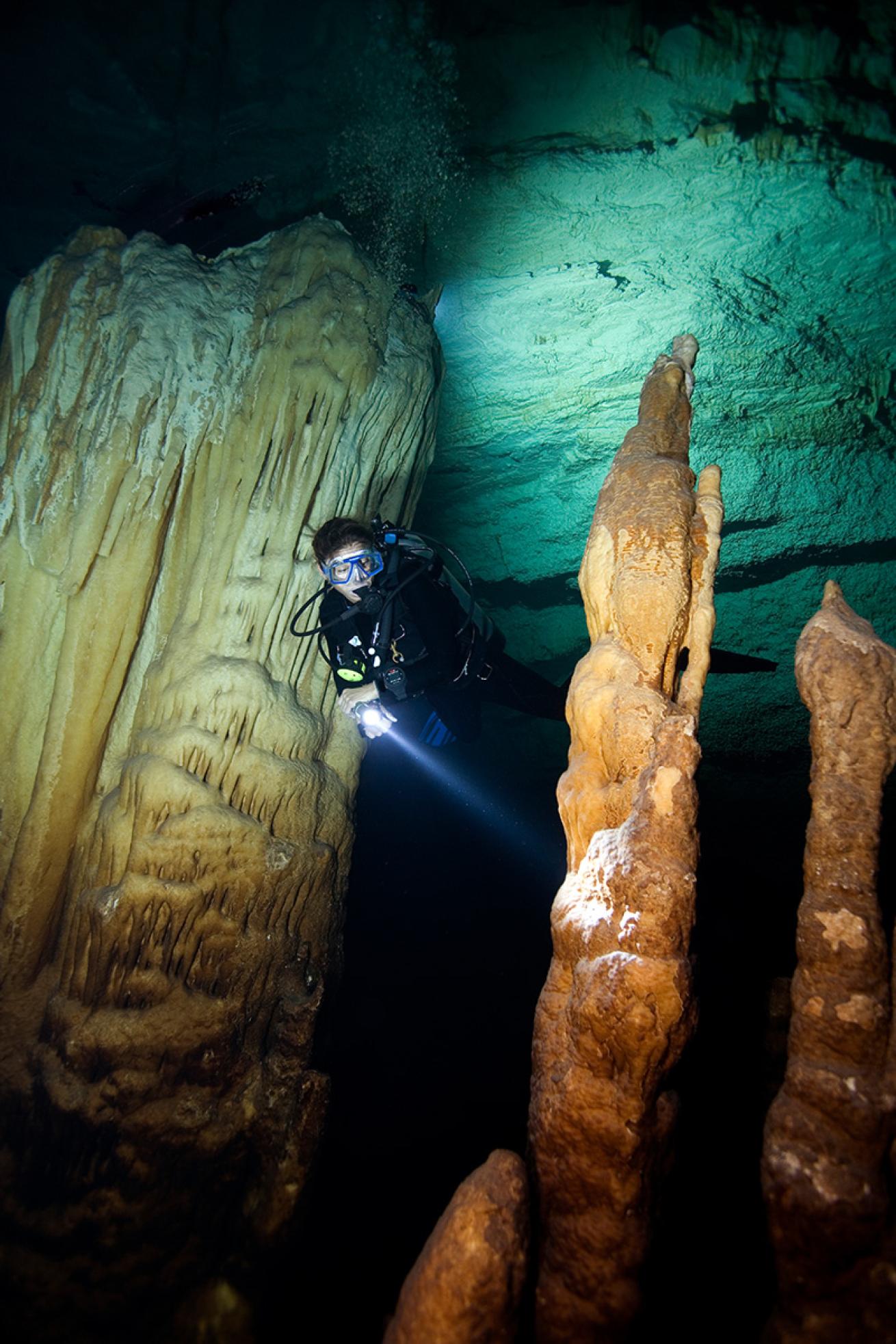 Diver with flashlight in cavern