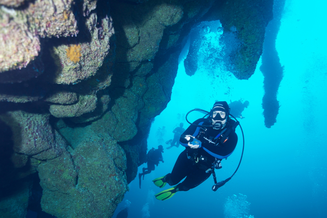 A scuba diver viewing rock structures