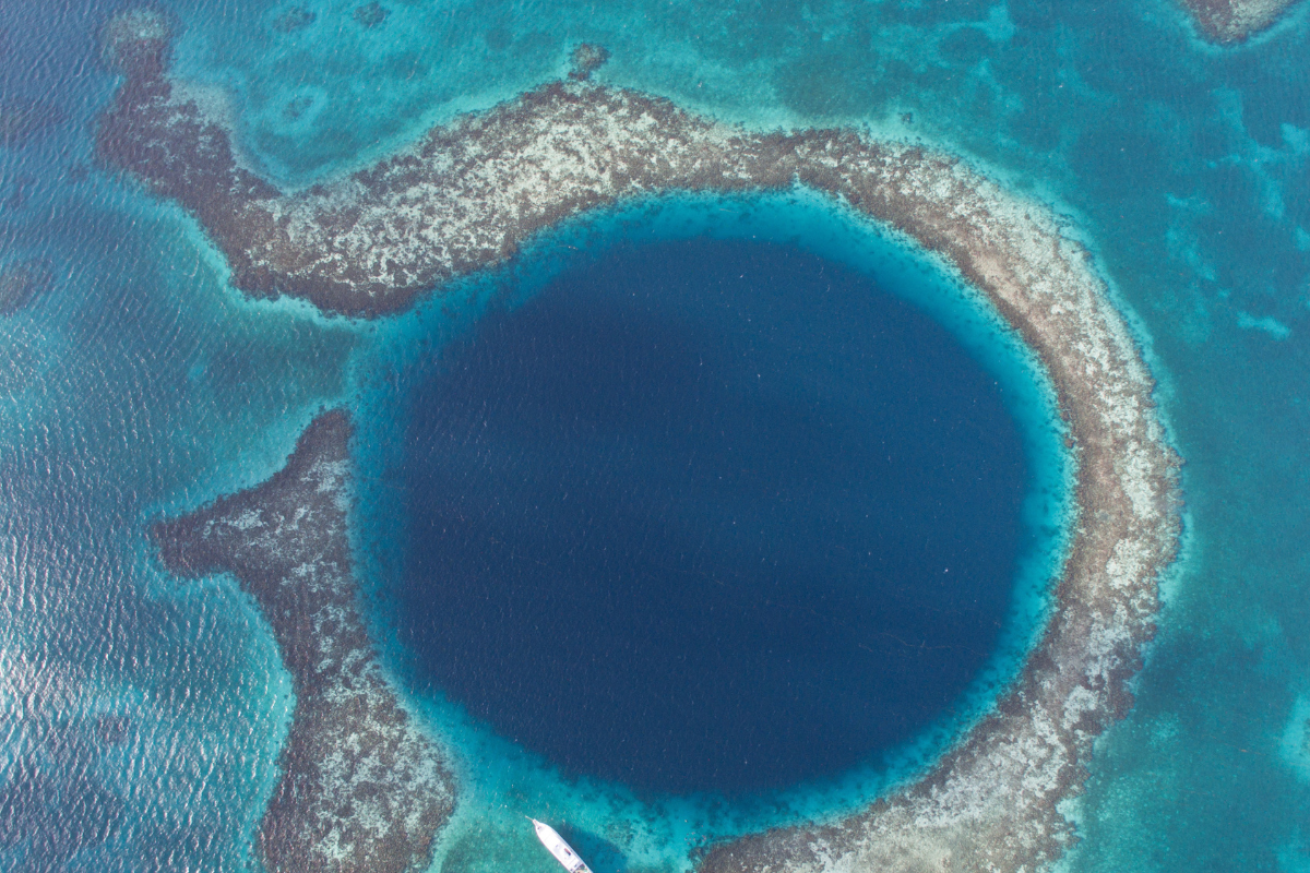 A boat anchored on the edge of a blue hole