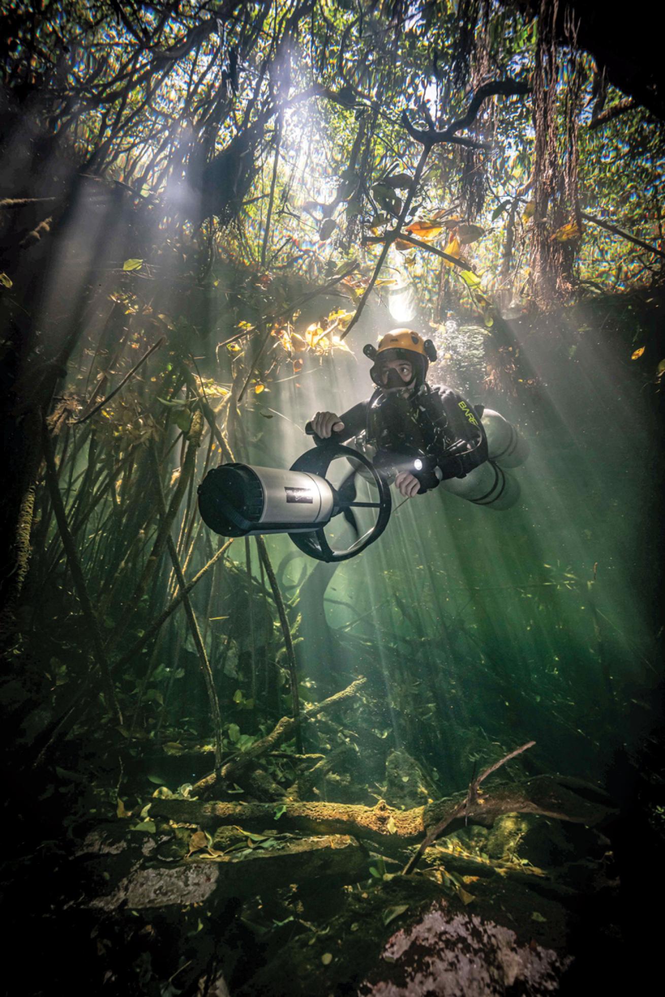 Cenote diver with DPV