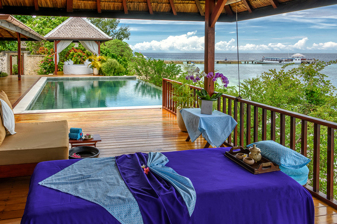 A bed overlooking the ocean and pool