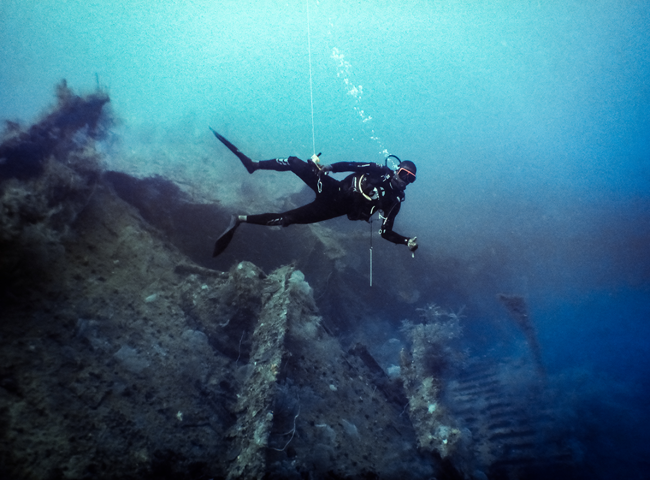 Diver going down to a shipwreck.