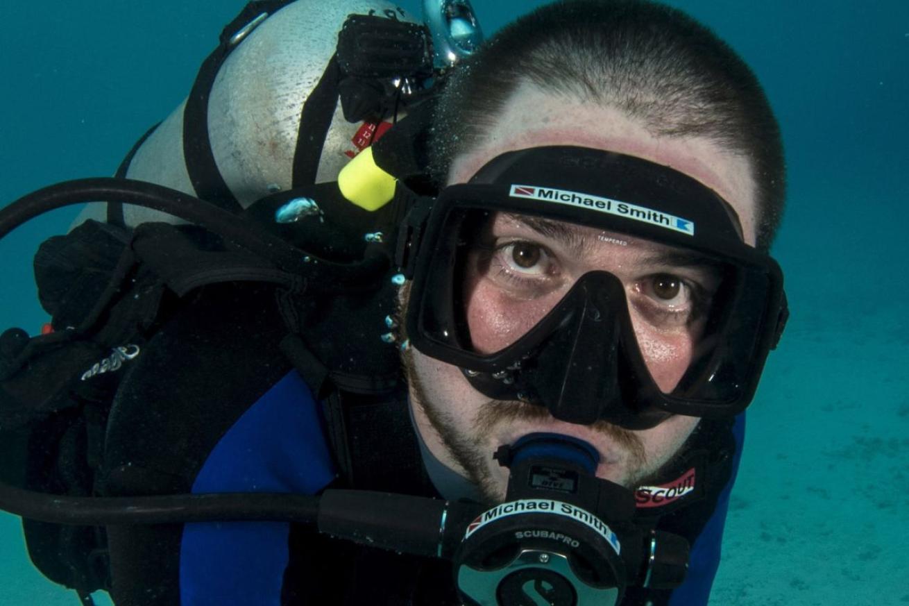 A male scuba diver underwater looking at camera