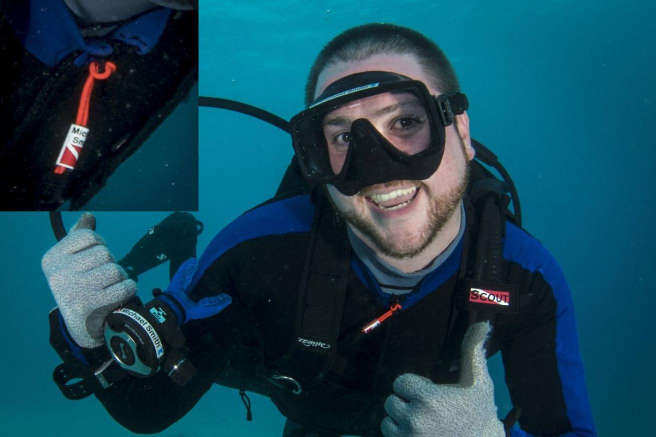 Male scuba diver smiling at camera with a thumbs up