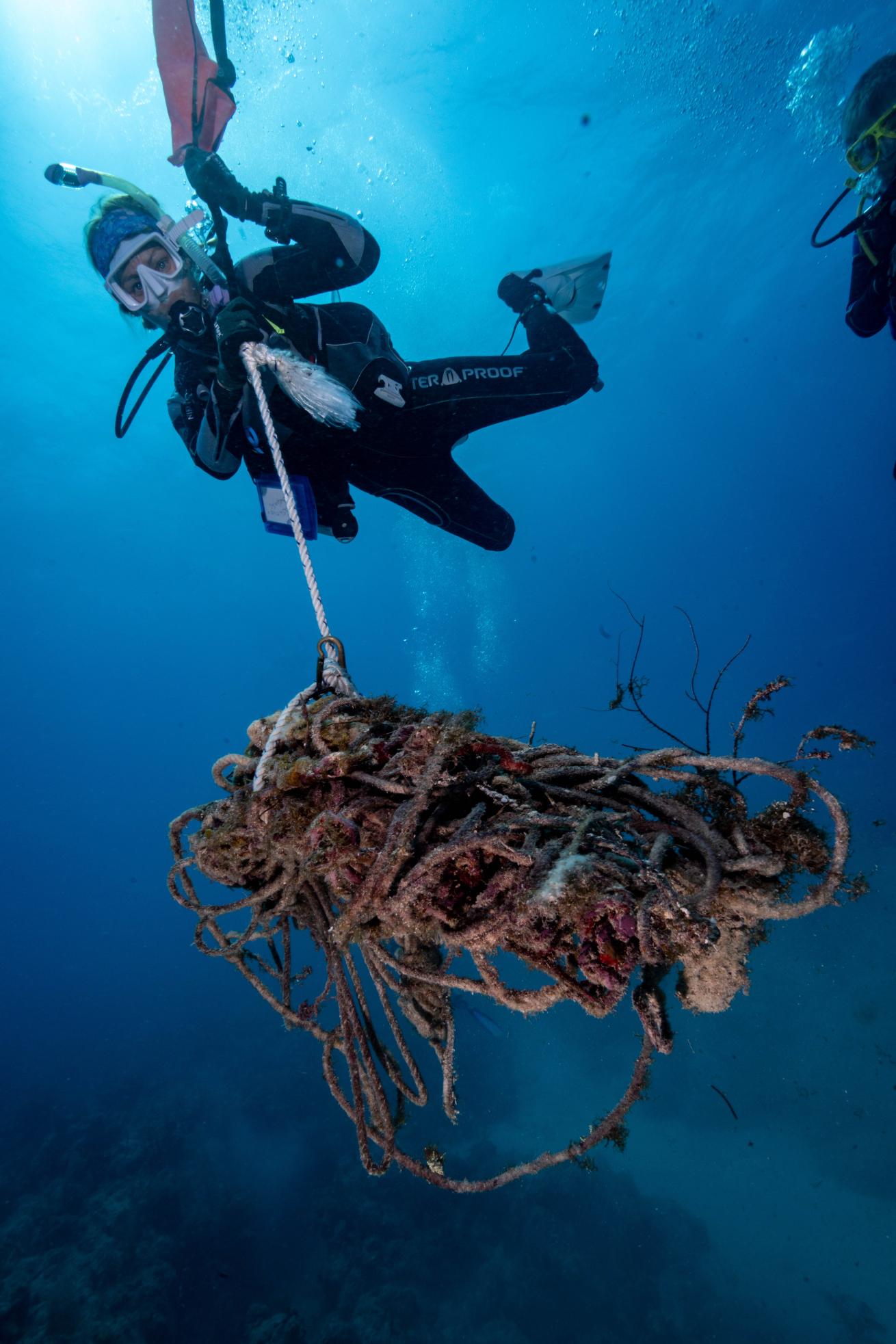 A diver lifts trash from the seafloor