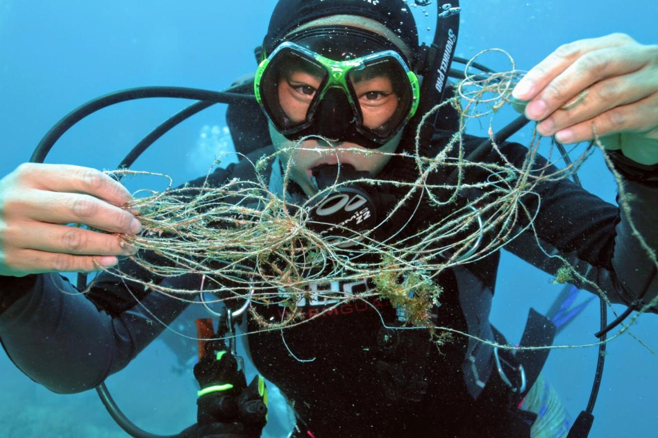 Author Tiffany Duong holds up monofilament, which appears invisible but wreaks havoc on fragile corals and wildlife by entangling them.