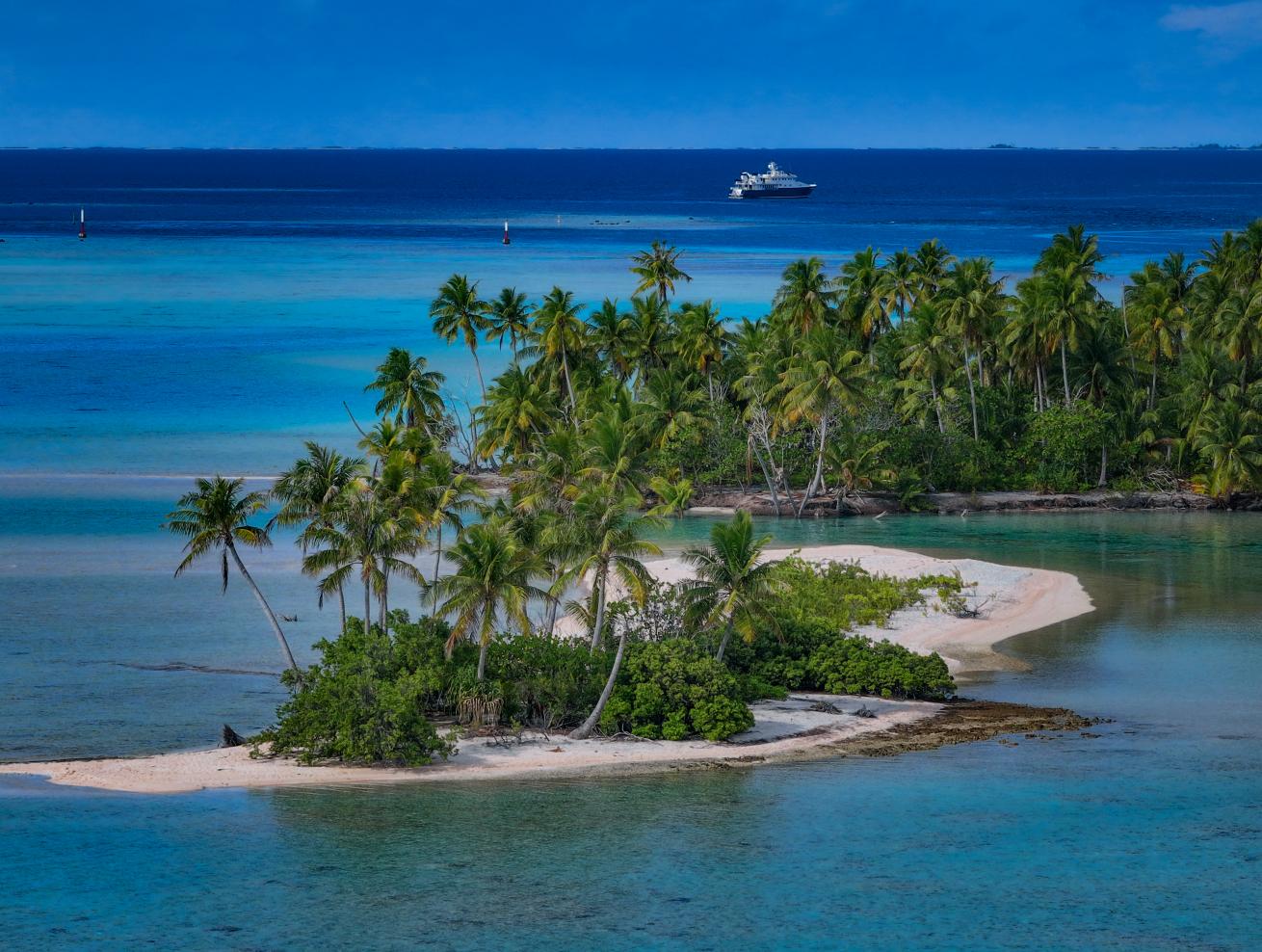 The Hanse Explorer, chartered by EYOS Expeditions, anchors near a French Polynesian atoll.