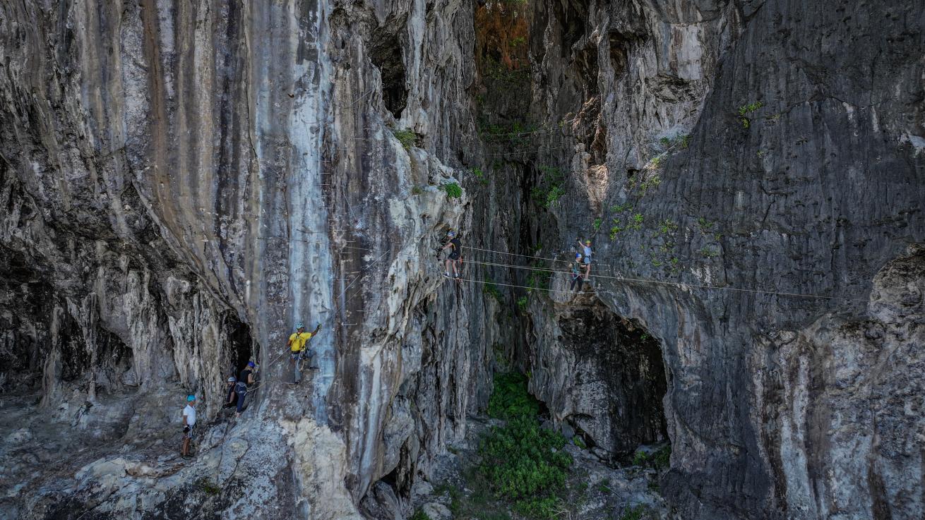 The author (in a green shirt) traverses a villa ferrata on Makatea during a day of land-based adventures organized by EYOS Expeditions.