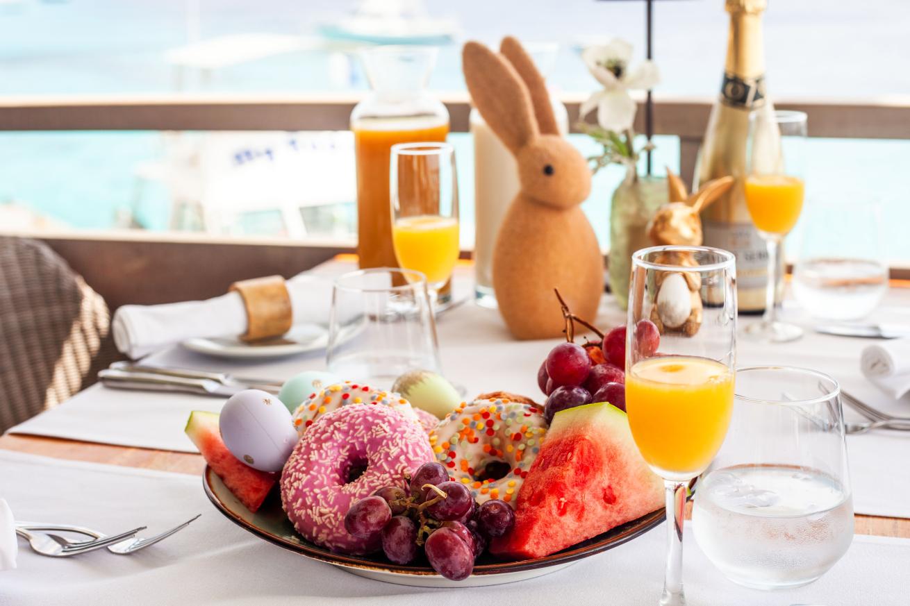 A plate of fruit and juice on a table at Easter brunch