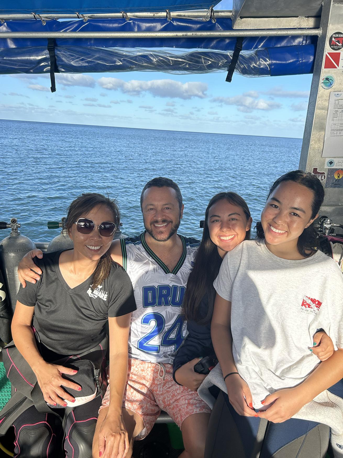 a family siting on a dive boat