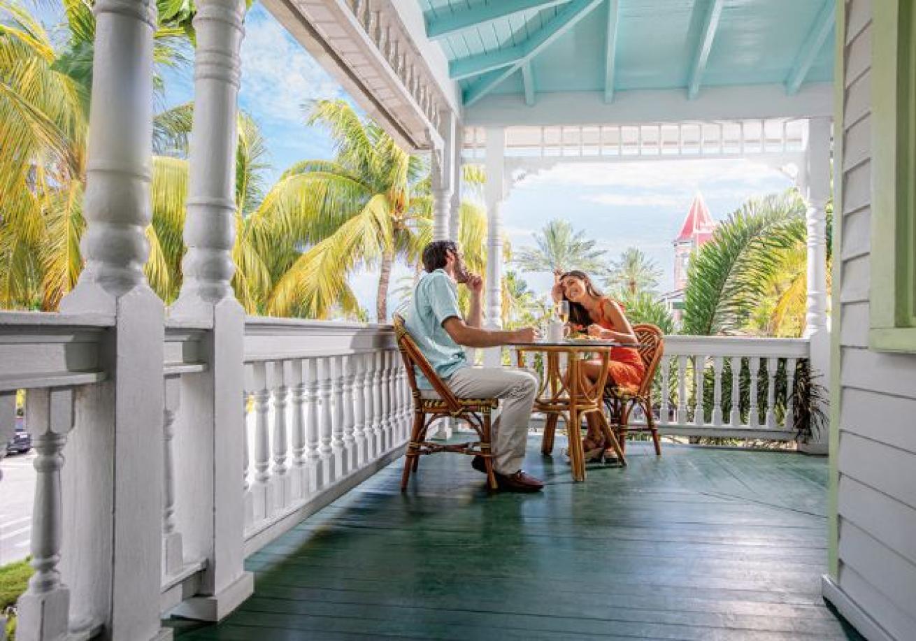 A person and person sitting at a table on a porch