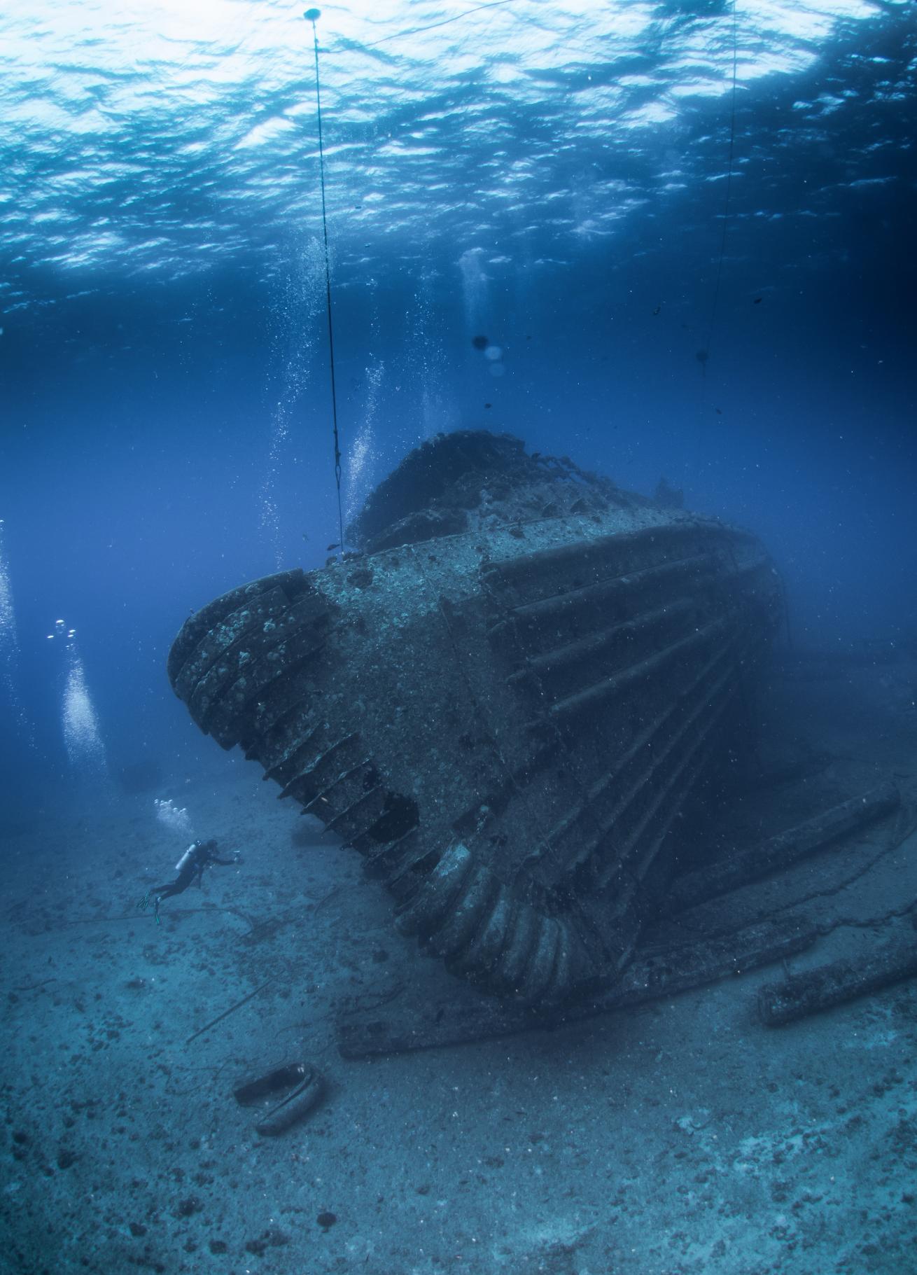 Scuba divers exploring underwater shipwreck in Oahu