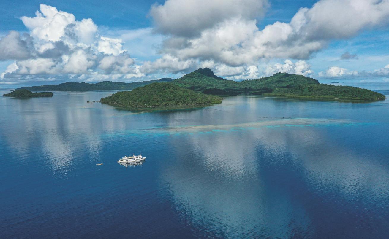 The island of Tonoas—known as Dublon during World War II—rises behind M/V *Odyssey* on the mooring for the*Nippo Maru* wreck.