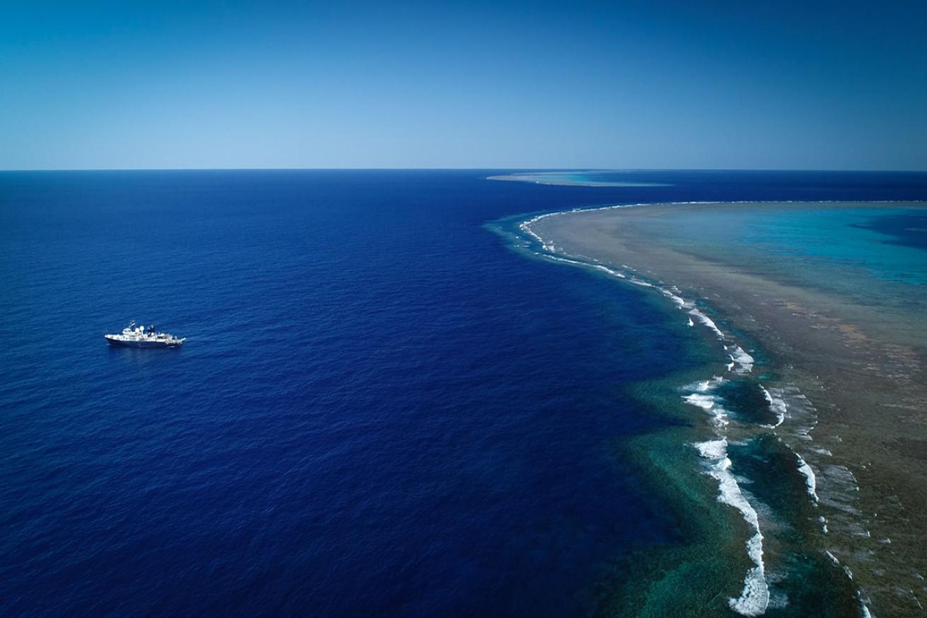 R/V Falkor floating near Ribbon Reef #5 in the Great Barrier Reef.