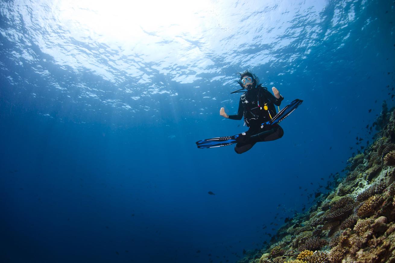 a diver doing a meditation pose underwater