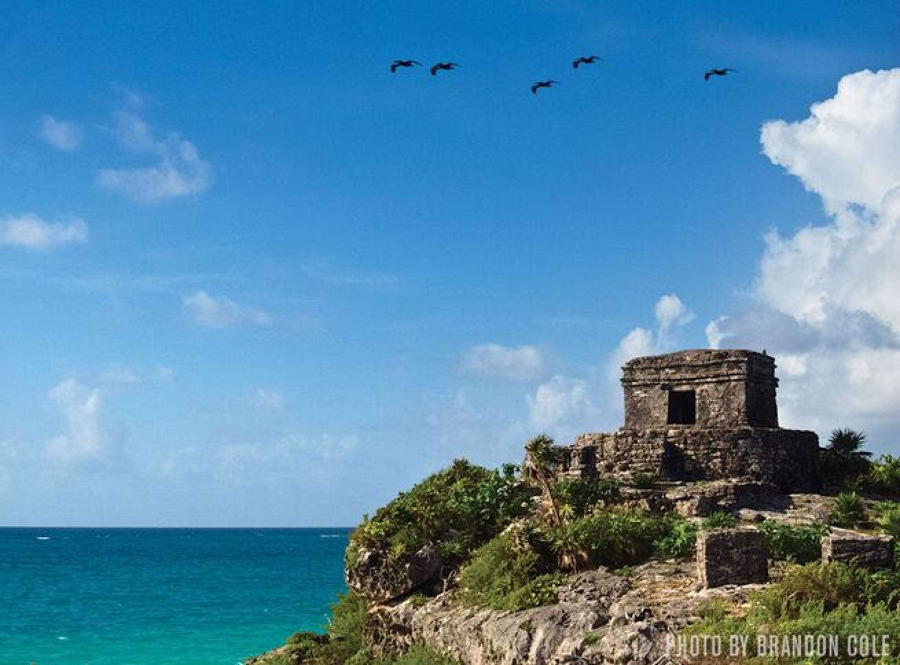 The ancient Mayan ruins of Tulum cling to the cliffs on the coastline.