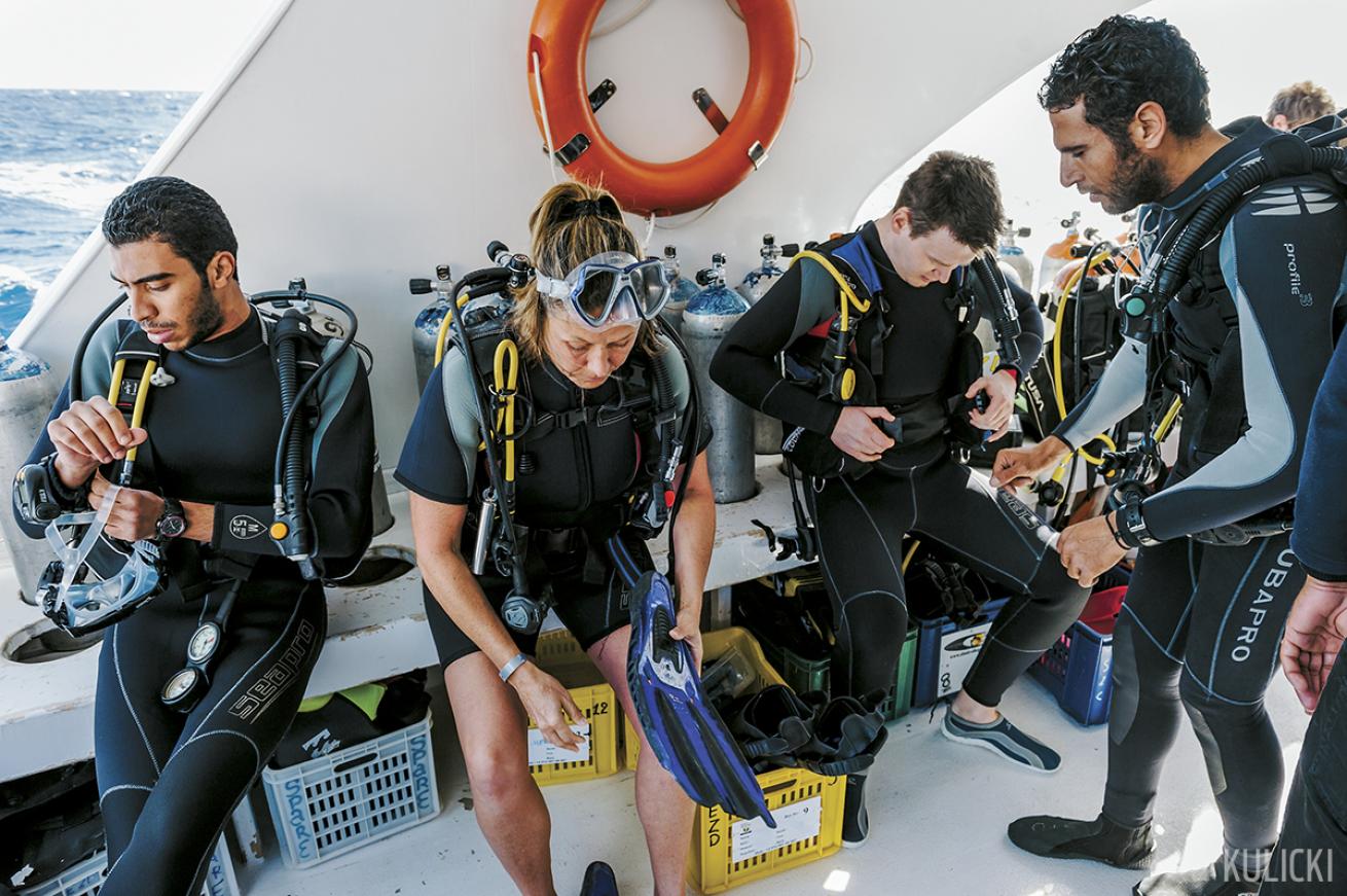people gearing up on dive boat