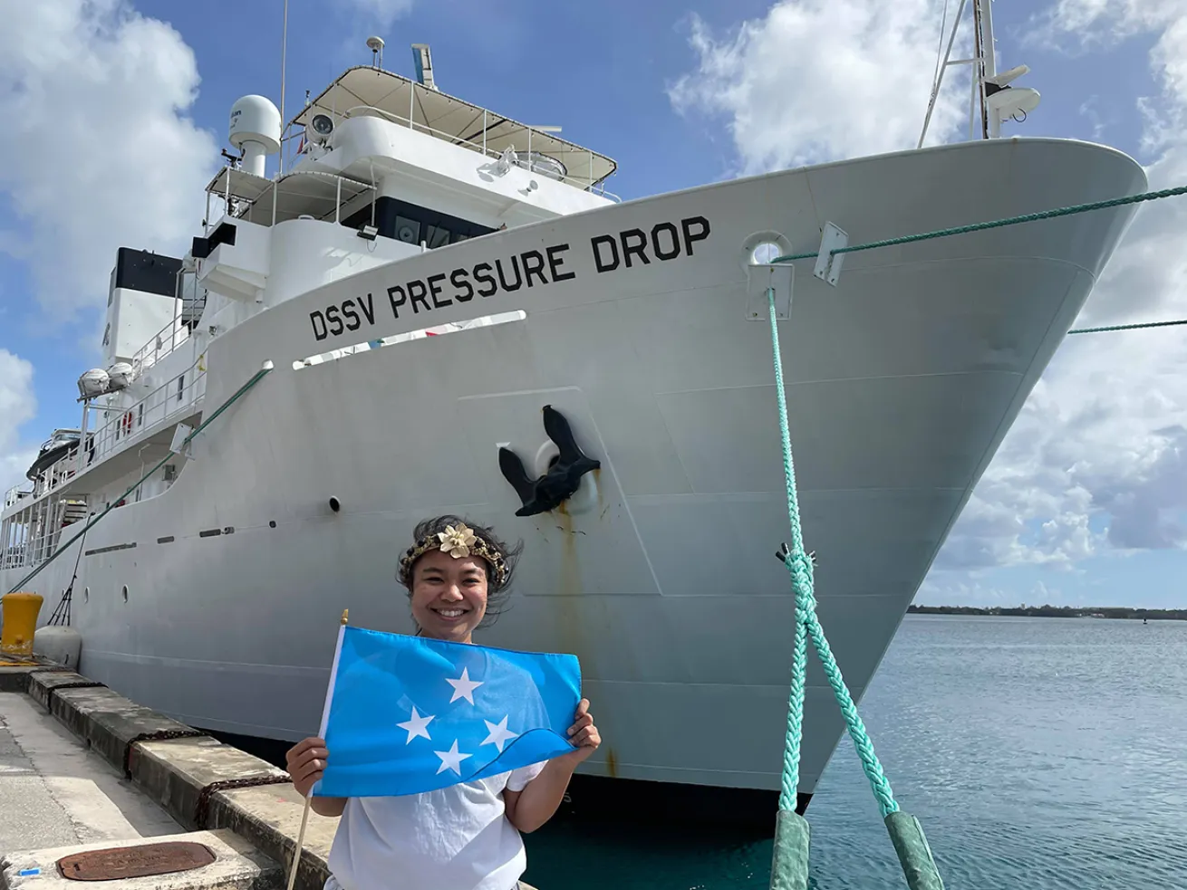Nicole Yamase holds the Micronesian flag next to the DSSV Pressure Drop