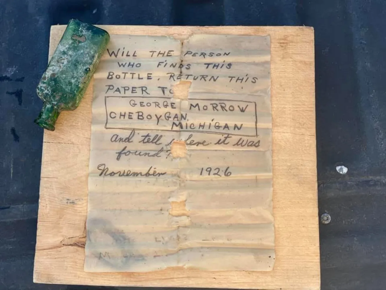 Waterlogged note next to a small green bottle