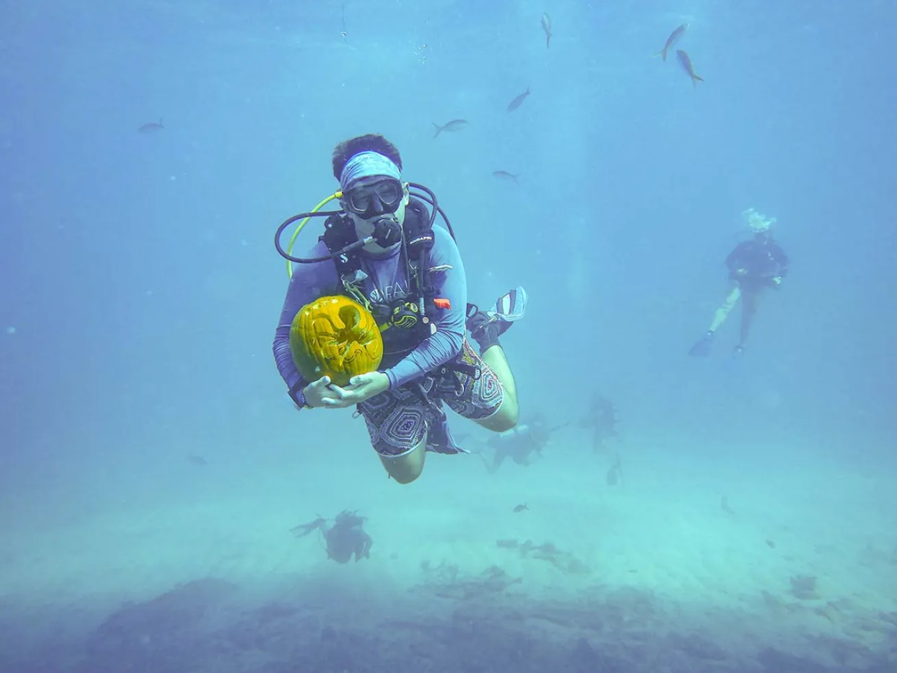 Diver underwater with jack-o-lantern
