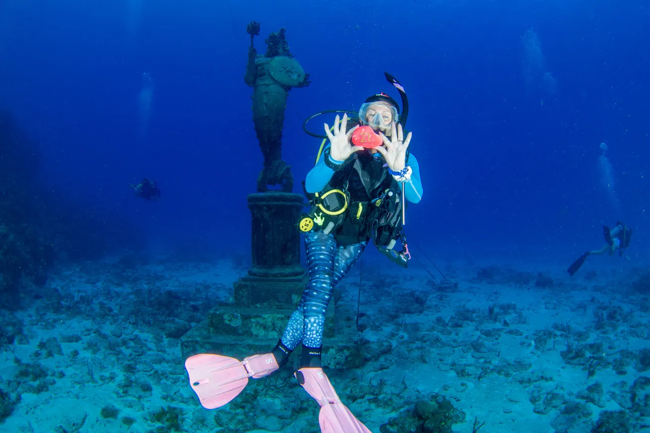 Female Diver doing underwater scavenger hunt 