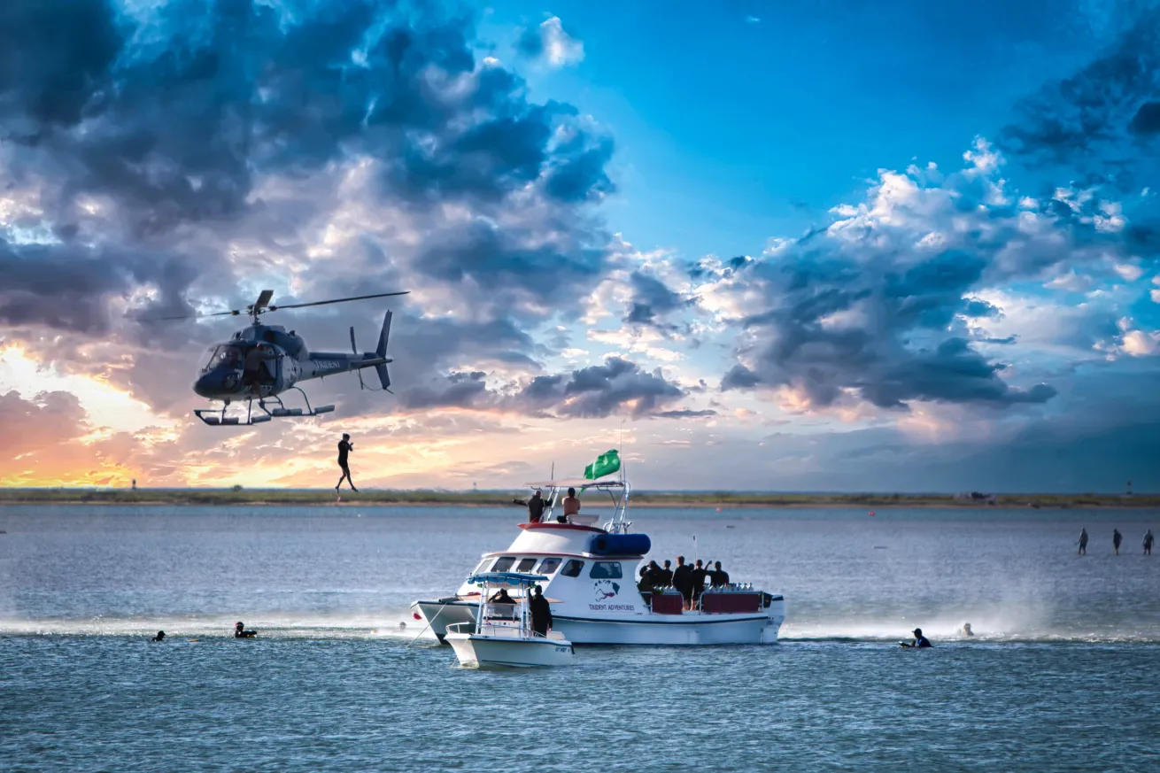 Diver jumping from helicopter into ocean.