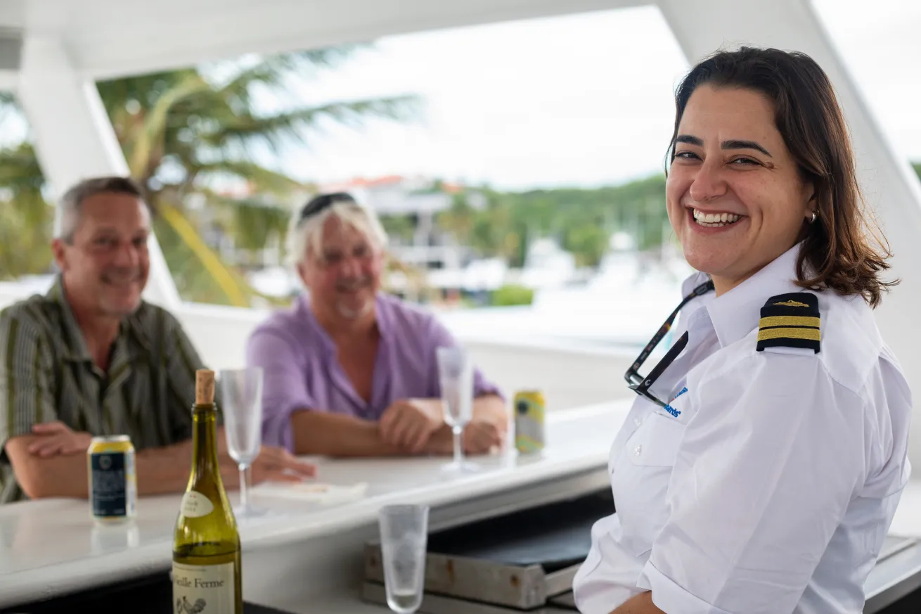Aggressor staff member serving wine and beer to guests aboard the Turks & Caicos Aggressor.